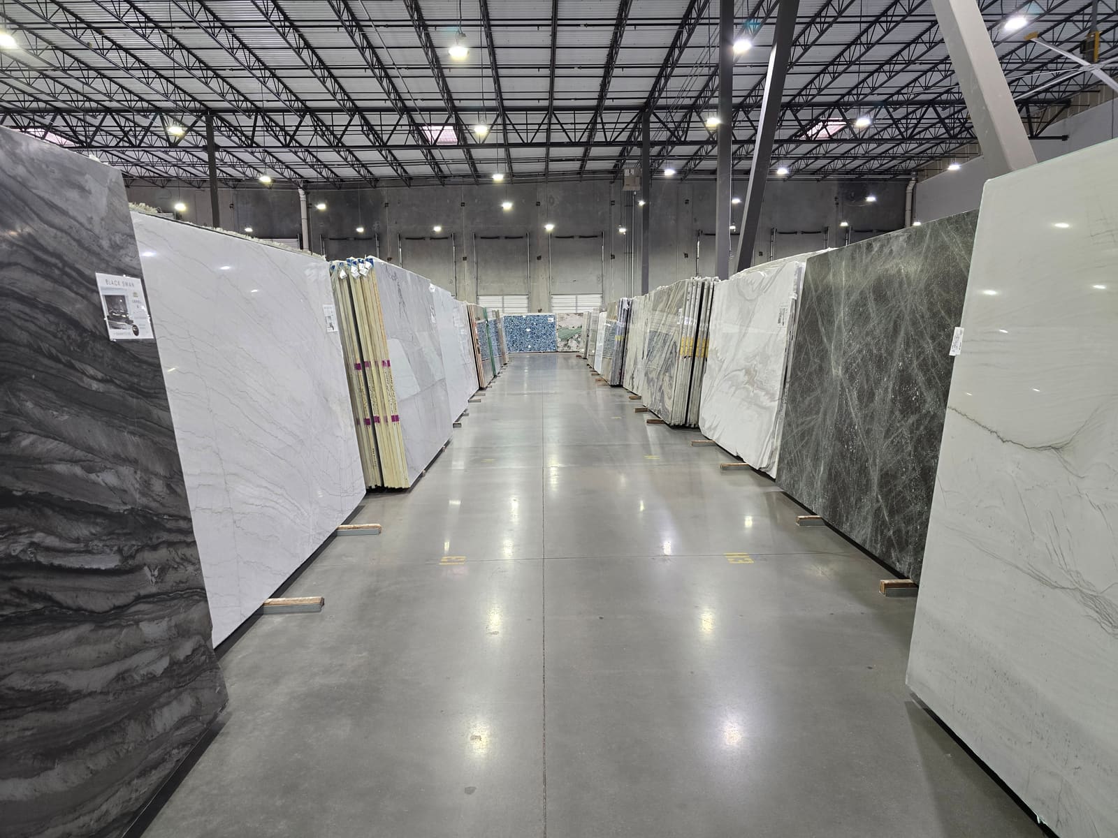 A gallery-lit aisle of full stone slabs on the CRS floor in Austin