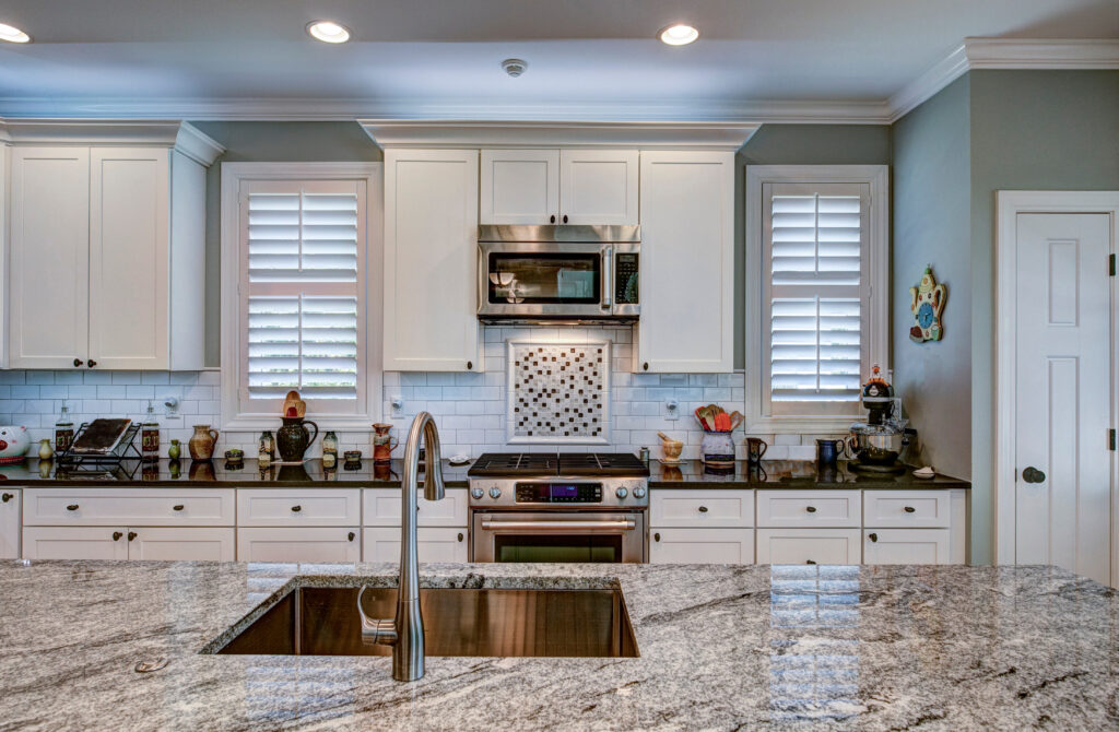 Luxury kitchen remodel with granite island in foreground.